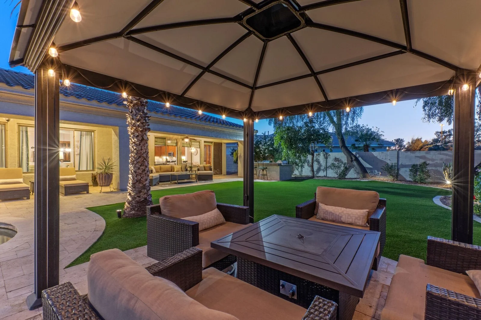 Arizona vacation rental home with pool and string lights at dusk